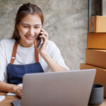 Startup small business entrepreneur SME, Young Asian Girl receive the order on phone and laptop at home office, small business online sell marketing delivery, SME e-commerce telemarketing concept