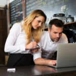 Two restaurant owners working with laptop